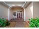 Inviting front porch with red double doors, white columns, and decorative plants at 2114 147Th E Ct, Bradenton, FL 34212