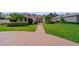 Charming single-story home with a brick driveway, green lawn, and manicured shrubs at 2114 147Th E Ct, Bradenton, FL 34212