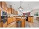 Open kitchen featuring wooden cabinets, granite countertops, stainless steel appliances, and a central island at 2114 147Th E Ct, Bradenton, FL 34212