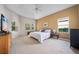 Inviting main bedroom with tray ceilings, large windows, carpeted floor, and neutral wall paint at 2114 147Th E Ct, Bradenton, FL 34212