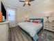 Relaxing bedroom featuring a bed with blue upholstered headboard, neutral walls and wood-look floors at 2160 Chenille Ct, Venice, FL 34292