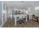 Bright eat-in kitchen featuring white cabinets, a large island with seating, and luxury vinyl floors at 2160 Chenille Ct, Venice, FL 34292