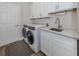 Efficient laundry room featuring modern appliances, white cabinets, and a functional sink area at 2160 Chenille Ct, Venice, FL 34292