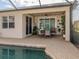 Relaxing outdoor patio with a dining set near the sparkling pool, and a decorative ceiling fan at 2160 Chenille Ct, Venice, FL 34292