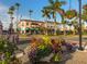 Beautiful street view showcasing a vibrant corner building with colorful flowers and palm trees at 2160 Chenille Ct, Venice, FL 34292