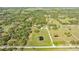 Aerial view showcasing the expansive acreage with mature trees and a peaceful pond at 2230 Myakka Rd, Sarasota, FL 34240