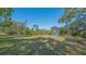 Exterior view of a two-story house in a sprawling grassy lot dotted with mature trees at 2230 Myakka Rd, Sarasota, FL 34240