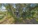 Home partially obscured by landscape, with a cozy backyard patio, fire pit, and outdoor seating at 2230 Myakka Rd, Sarasota, FL 34240