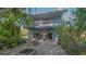 A cozy backyard patio with a fire pit and outdoor seating, surrounded by lush tropical landscaping and a two story home at 2230 Myakka Rd, Sarasota, FL 34240