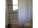 Bright bathroom featuring a shower with white subway tile, a sleek shower curtain, and a modern toilet at 22337 Olean Blvd, Port Charlotte, FL 33952