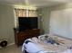 Cozy bedroom featuring a decorative dresser, large television, and a ceiling fan for comfortable living at 22337 Olean Blvd, Port Charlotte, FL 33952