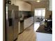 Bright kitchen featuring stainless steel refrigerator, white cabinets, and tiled backsplash at 22337 Olean Blvd, Port Charlotte, FL 33952