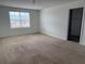 Carpeted bedroom filled with natural light from a window, next to an open doorway at 2409 Sand Gables Trl, Bradenton, FL 34208
