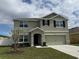 Inviting two-story home with a well-maintained lawn, and neutral color palette at 2409 Sand Gables Trl, Bradenton, FL 34208