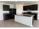 Stylish kitchen featuring dark cabinetry, granite countertops, and a center island at 2409 Sand Gables Trl, Bradenton, FL 34208