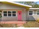 Close up of the pink front door with white trim and brick base at 3181 Alta Vista St, Sarasota, FL 34237