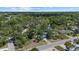 Aerial view of the home showcasing the surrounding trees, neighborhood, and nearby lake at 3466 Tanglewood Dr, Sarasota, FL 34239