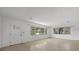 Large living room featuring a front door and large windows providing natural light and views of the yard at 3466 Tanglewood Dr, Sarasota, FL 34239