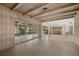 Open-concept living room with exposed beam ceiling, tile floors, and multiple sliding glass doors to the yard at 3466 Tanglewood Dr, Sarasota, FL 34239