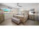 Bright bedroom featuring a wooden bed frame, ceiling fan, and tiled floor at 3502 18Th Avenue W Dr, Bradenton, FL 34205