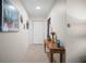 Bright hallway featuring neutral tile floors, a wooden console table, and closet space at 3502 18Th Avenue W Dr, Bradenton, FL 34205