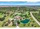 Expansive aerial view showcasing the property's mature landscaping, private pond, and surrounding acreage at 3551 Ridgeland Ct, Punta Gorda, FL 33982