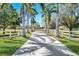 Long driveway lined with palm trees and white fencing creates an appealing entrance to the property at 3551 Ridgeland Ct, Punta Gorda, FL 33982