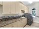 Well-equipped laundry room with granite countertops, ample cabinet space, and modern machines at 3551 Ridgeland Ct, Punta Gorda, FL 33982