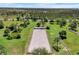 Equestrian arena with well-maintained sand, surrounded by green pastures, trees, and white fencing at 3551 Ridgeland Ct, Punta Gorda, FL 33982