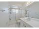 Bright bathroom featuring white tile floors, a vanity with a large mirror, and a tub and shower combination at 3909 Linwood St, Sarasota, FL 34232