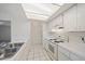 Bright kitchen with white cabinets, backsplash, countertops, and stainless steel sink at 3909 Linwood St, Sarasota, FL 34232