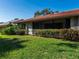 Home's backyard with healthy green grass and beautiful landscaping around the house at 3922 Wilshire Cir # 177, Sarasota, FL 34238
