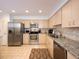 Well-lit kitchen featuring stainless steel appliances, granite countertops, and neutral-toned cabinets at 3922 Wilshire Cir # 177, Sarasota, FL 34238
