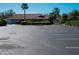 A parking lot in front of a building with a red tile roof and green landscaping at 3922 Wilshire Cir # 177, Sarasota, FL 34238