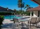 Community pool area featuring lounge chairs, tables, and tropical landscaping at 3922 Wilshire Cir # 177, Sarasota, FL 34238