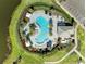 Beautiful aerial view of community pool and jacuzzi surrounded by lush landscaping and lounge chairs at 4253 Pond Brook Ct, Bradenton, FL 34211