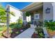 Inviting front porch with a charming seating area, lush flowers, and a hanging fern at 4253 Pond Brook Ct, Bradenton, FL 34211