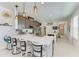Bright kitchen features a large island with quartz countertops, pendant lighting, and stainless steel appliances at 4253 Pond Brook Ct, Bradenton, FL 34211