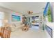 Bright living room featuring a ceiling fan, modern decor, and seamless transition to the outdoor patio and pool area at 4253 Pond Brook Ct, Bradenton, FL 34211