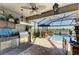 Enclosed outdoor kitchen featuring stainless steel grill, countertops, and a stunning pool view at 4253 Pond Brook Ct, Bradenton, FL 34211