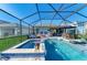 Luxurious screened-in pool and spa with an outdoor seating area, lush greenery, and a sunny ambiance at 4253 Pond Brook Ct, Bradenton, FL 34211