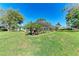 Expansive screened-in lanai and backyard with lush green grass and well-maintained landscaping at 4283 Southwell Way, Sarasota, FL 34241