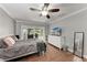 Comfortable bedroom featuring wood floors, ceiling fan and sliding glass doors to the outside at 4283 Southwell Way, Sarasota, FL 34241