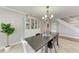 The dining room offers neutral paint and decor, bright light fixture, and staircase access at 4283 Southwell Way, Sarasota, FL 34241