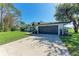 Home featuring an expansive driveway leading to an attached garage and well-manicured lawn at 4283 Southwell Way, Sarasota, FL 34241