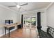 Office area features a desk, a black couch, French doors to the yard and ceiling fan at 4283 Southwell Way, Sarasota, FL 34241