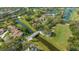 Stunning aerial view of a home nestled along a golf course and waterway in a lush, gated community at 4404 Calle Serena, Sarasota, FL 34238