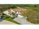 Aerial view of a pristine home with manicured lawns, an inviting driveway, and a classic red tile roof at 4404 Calle Serena, Sarasota, FL 34238