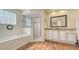 Bright bathroom features a tub, glass block window, and glass enclosed shower at 4404 Calle Serena, Sarasota, FL 34238