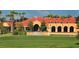 View of the beautiful clubhouse featuring a manicured lawn and a putting green at 4404 Calle Serena, Sarasota, FL 34238